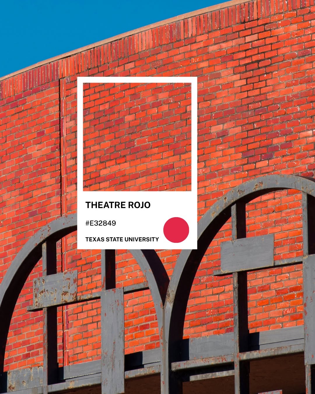 Tường gạch đỏ và khung thép vòm của nhà hát trong khuôn viên Texas State — chip màu Theatre Rojo #E32849